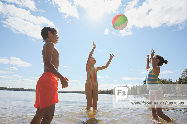 Kinder stehen im See und spielen mit einem Strandball; Ontario  Kanada'.