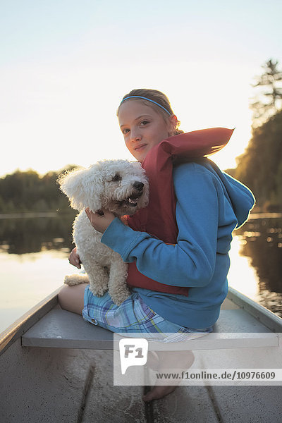 Mädchen sitzt mit ihrem Hund in einem Kanu auf dem Crystal Lake; Ontario  Kanada'.