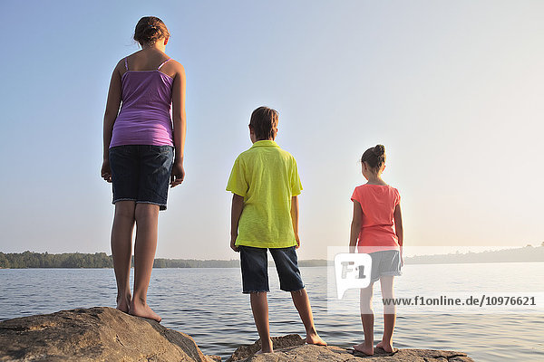 'Kids standing on rock at edge of Crystal Lake; Ontario  Canada'