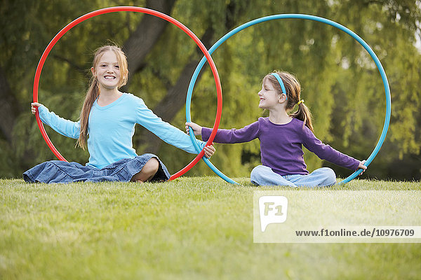 Junge Mädchen spielen mit Hula-Hoop-Reifen in einem Park; Toronto  Ontario  Kanada'.