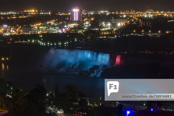 'Night view of American Falls against lights of the city; Niagara Falls  New York  USA'