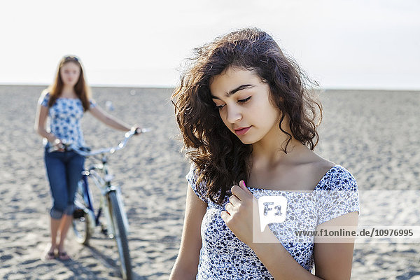 Zwei Mädchen stehen mit Fahrrad am Strand; Toronto  Ontario  Kanada'.