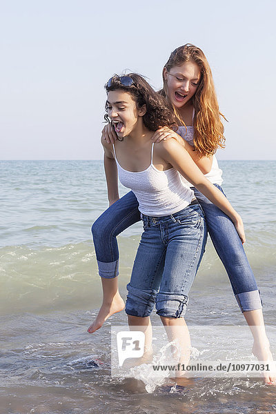 Zwei Mädchen spielen Huckepack am Strand; Toronto  Ontario  Kanada'.