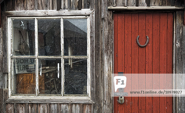Holzgebäude mit rot gestrichener Tür  Vorhängeschloss und Fenster; Beamish  Durham  England'.