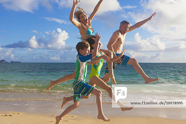 Eine vierköpfige Familie am Strand auf einer hawaiianischen Insel; Kailua  Insel Hawaii  Hawaii  Vereinigte Staaten von Amerika'.