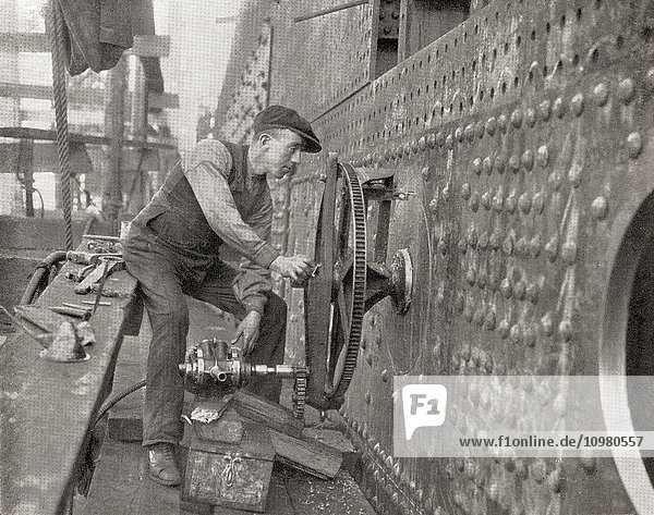 Arbeiter  der ein pneumatisches Werkzeug zum Ausschneiden von Seitenfenstern verwendet. Aus The Romance of the Merchant Ship  veröffentlicht 1931.