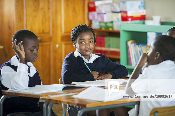 Junge Schüler arbeiten in einem Klassenzimmer; Hammanskraal  Gautang  Südafrika'.