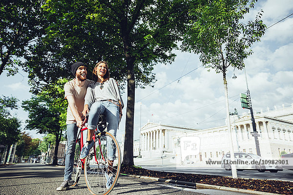 Österreich  Wien  junges Paar mit Fahrrad in der Nähe des Parlamentsgebäudes