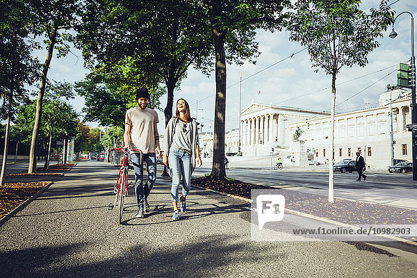Österreich  Wien  junges Paar mit Fahrrad vor dem Parlamentsgebäude