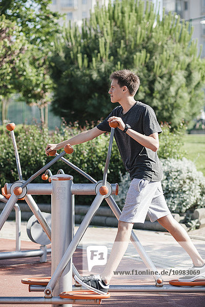 Teenager exercising on outdoor fitness equipment