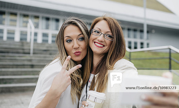 Zwei Frauen nehmen Selfie mit Smartphone mit nach draußen