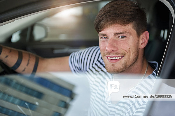 Portrait of smiling young man in car