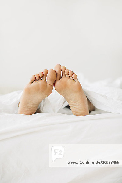 Feet of woman lying in bed