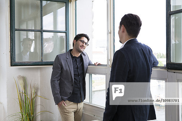 Two businessman standing at the window  talking