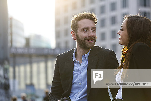Smiling young businesswoman and businessman outdoors