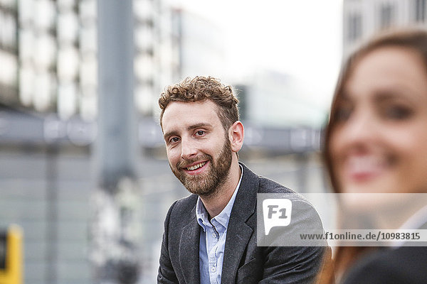 Smiling young businessman and businesswoman outdoors