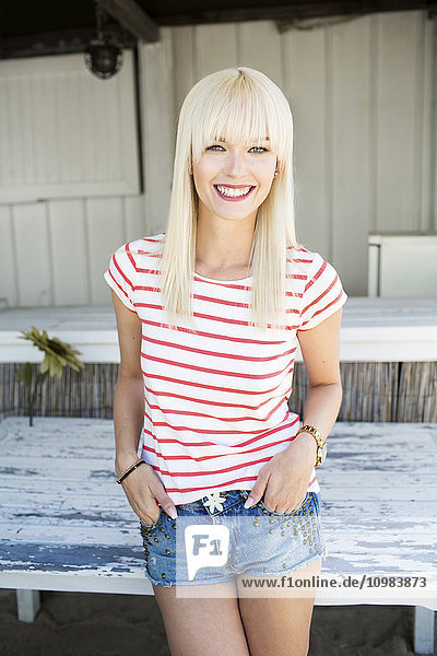 Portrait of smiling blond woman wearing striped t-shirt and Hot Pants