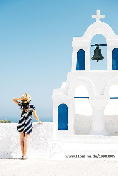 Griechenland  Santorini  Oia  Rückansicht der Frau neben dem Glockenturm mit Blick auf das Meer