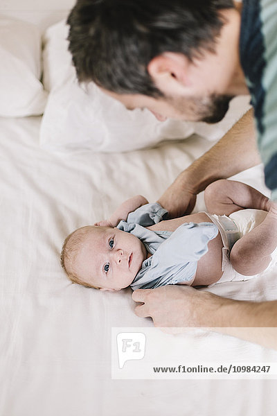 Father with baby boy at home  dressing