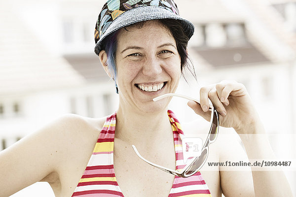 Portrait of laughing woman wearing bikini top and cap
