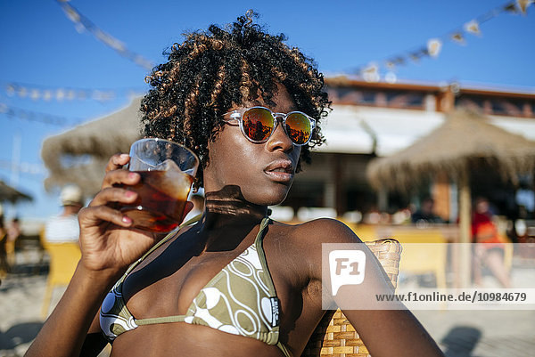 Young woman having a drink in a beach bar