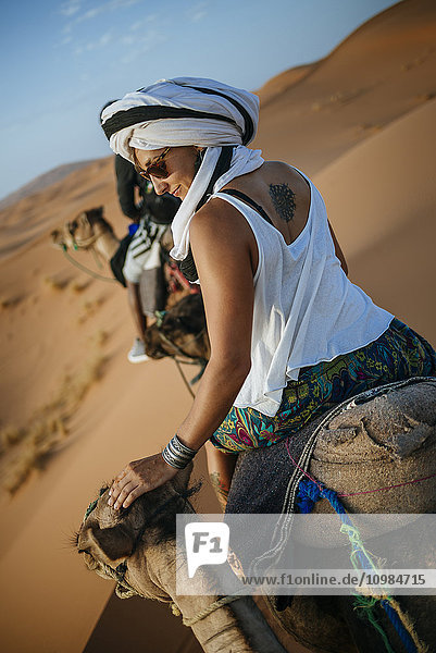 Frau mit Turban auf einem Kamel in der Wüste