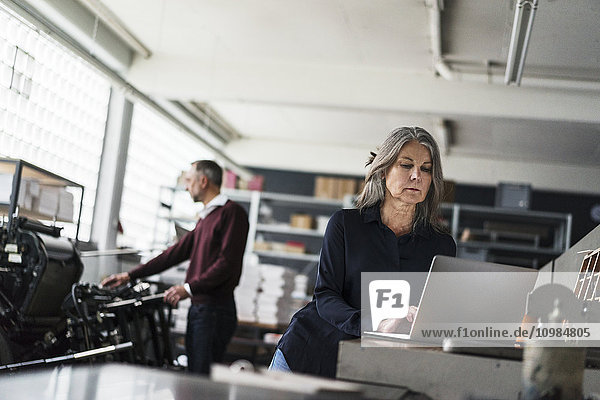 Senior Frau eine Druckerei mit Laptop