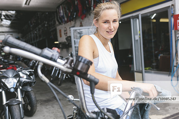 Lächelnde junge Frau auf dem Motorrad