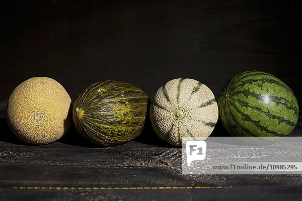 Vier verschiedene Melonen vor dunklem Hintergrund