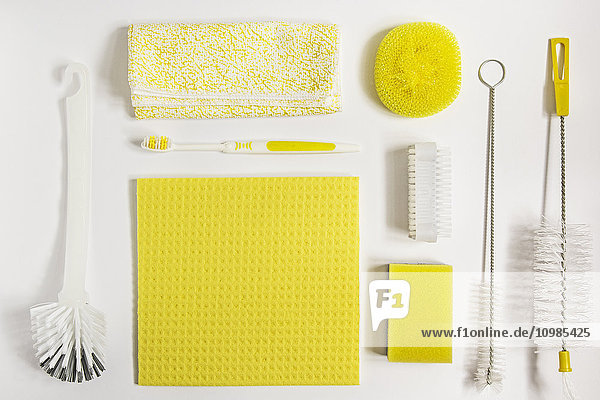 Yellow cleaning utensils on white background