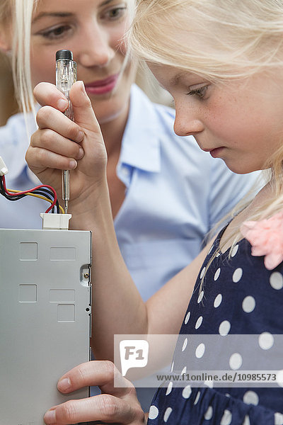 Kleines Mädchen überprüft Stromfluss des Computers
