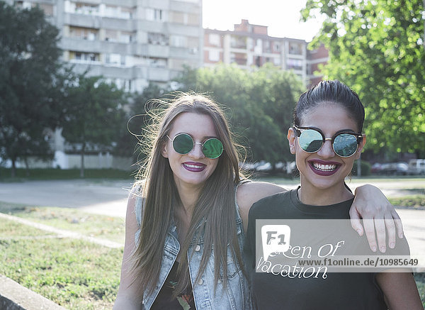 Porträt zweier modischer Freundinnen mit verspiegelter Sonnenbrille