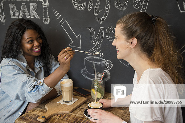 Zwei Freunde treffen sich im Cafe  teilen sich einen Kaffee