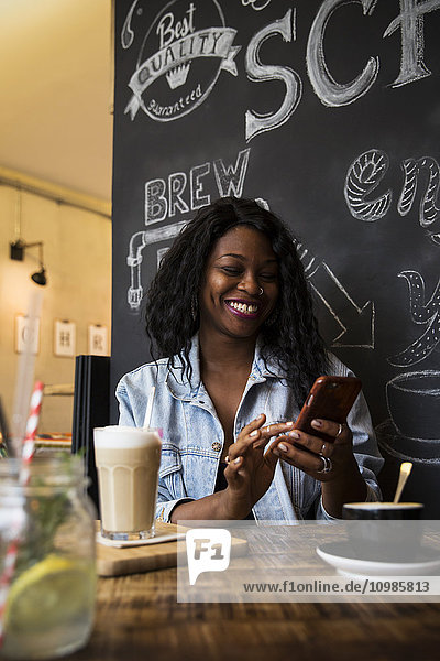 Frau im Café mit Smartphone