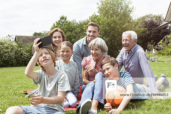 Junge nimmt Selfie der glücklichen Großfamilie in den Garten