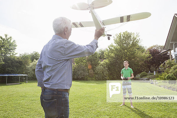 Großvater und Enkel mit Modellflugzeug im Garten