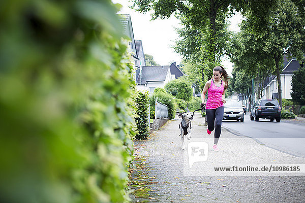Young woman jogging with dog