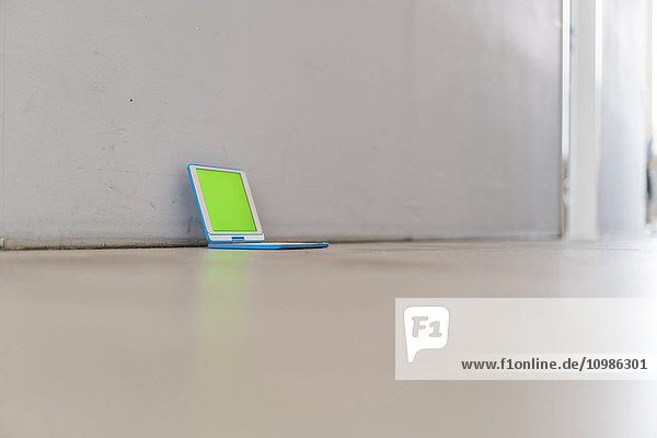 Digitales Tablett mit grünem Bildschirm auf dem Boden des Büros