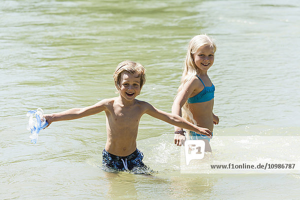 Der kleine Junge und seine Schwester baden in einem Fluss.