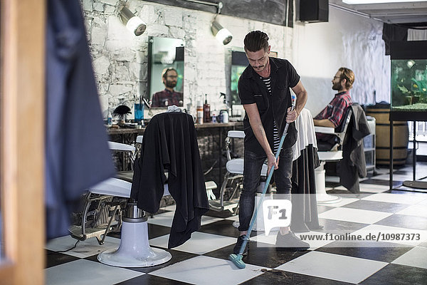Barber sweeping in barber's shop