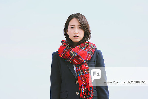 Japanese high-school student with scarf against blue sky
