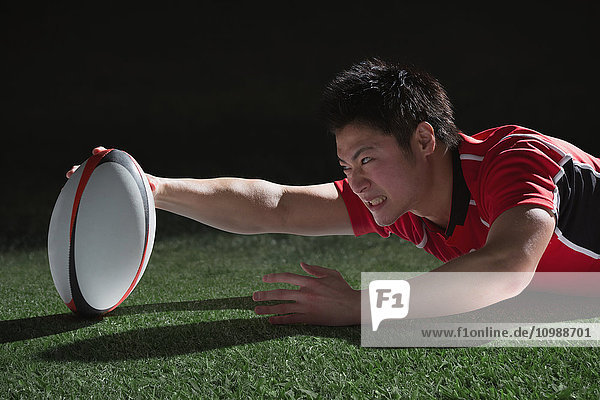 Porträt eines japanischen Rugbyspielers  der nach einem Versuch taucht
