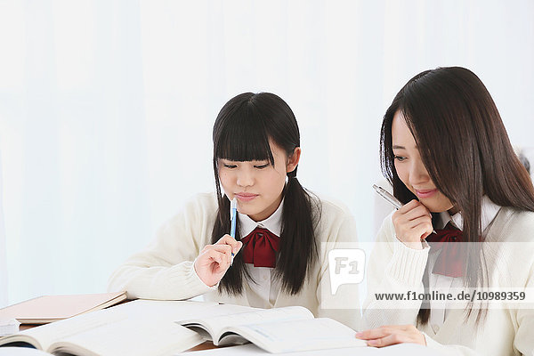 Japanische Gymnasiasten in Uniform beim gemeinsamen Lernen