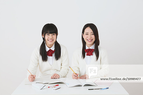 Japanische Gymnasiasten in Uniform beim gemeinsamen Lernen