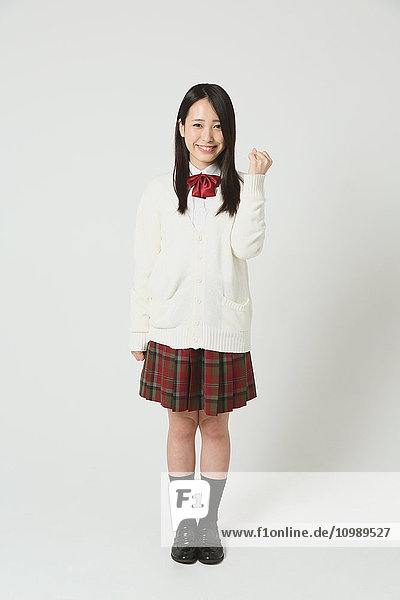 Japanischer Gymnasiast in Uniform vor weißem Hintergrund