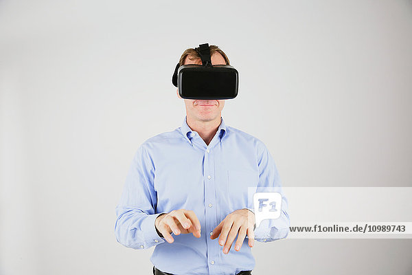 Kaukasischer Mann  der ein Virtual-Reality-Gerät benutzt