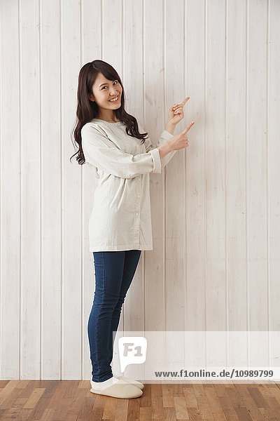 Young Japanese woman against wooden wall