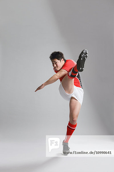 Porträt eines japanischen Rugbyspielers beim Kicken