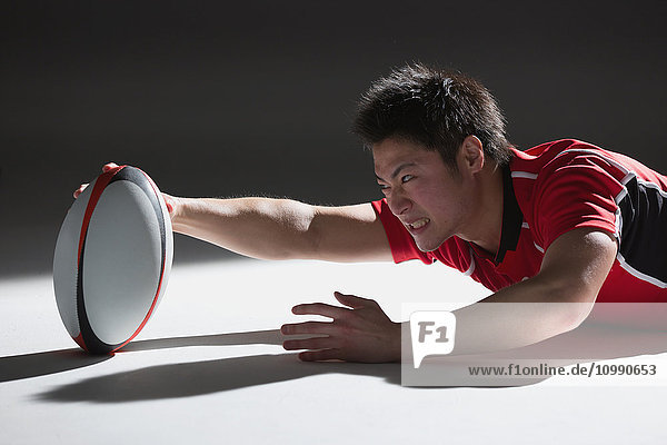 Porträt eines japanischen Rugbyspielers  der nach einem Versuch taucht