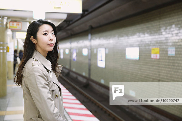 Junge attraktive Japanerin  die auf den Zug wartet